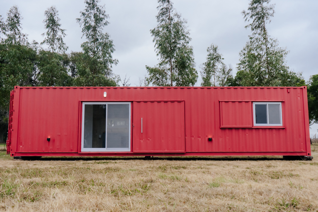Vista frontal de un módulo de vivienda realizado en un container rojo