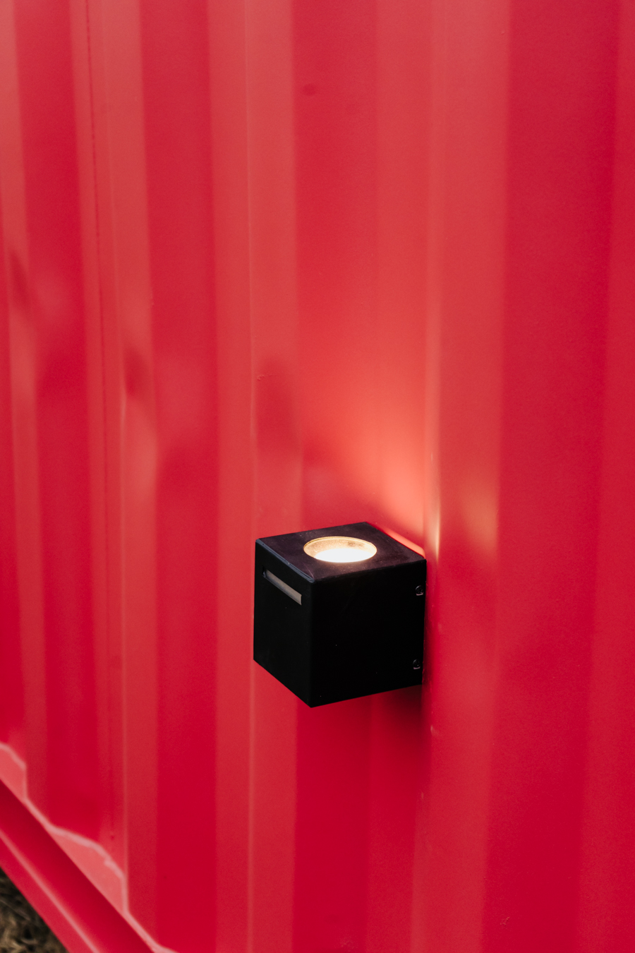 Ambiente interior iluminado, con puerta ventana y cocina al fondo